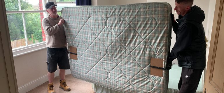 Moving a mattress using mattress carrier clamps